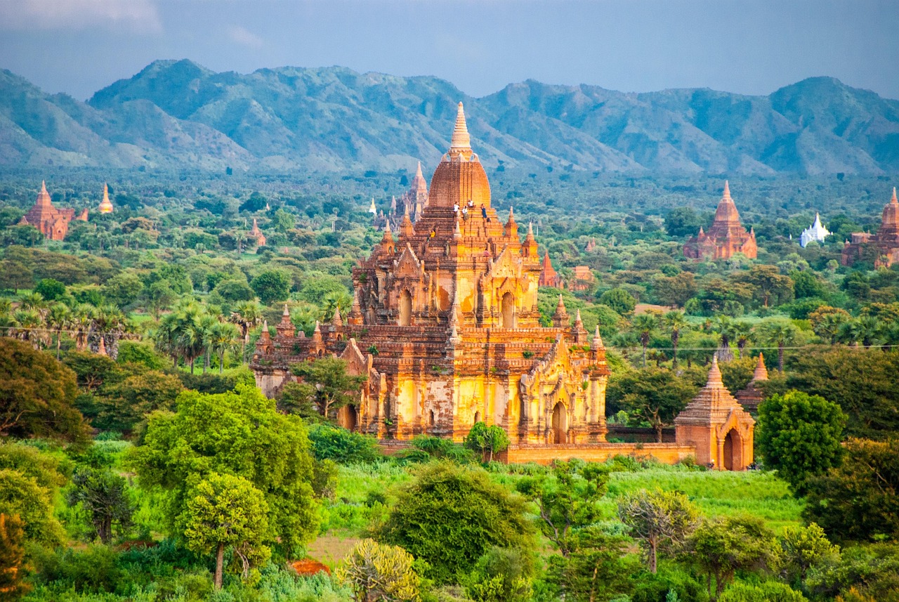 Aerial view of ancient brick temples and pagodas scattered across the plains of Bagan at sunrise.